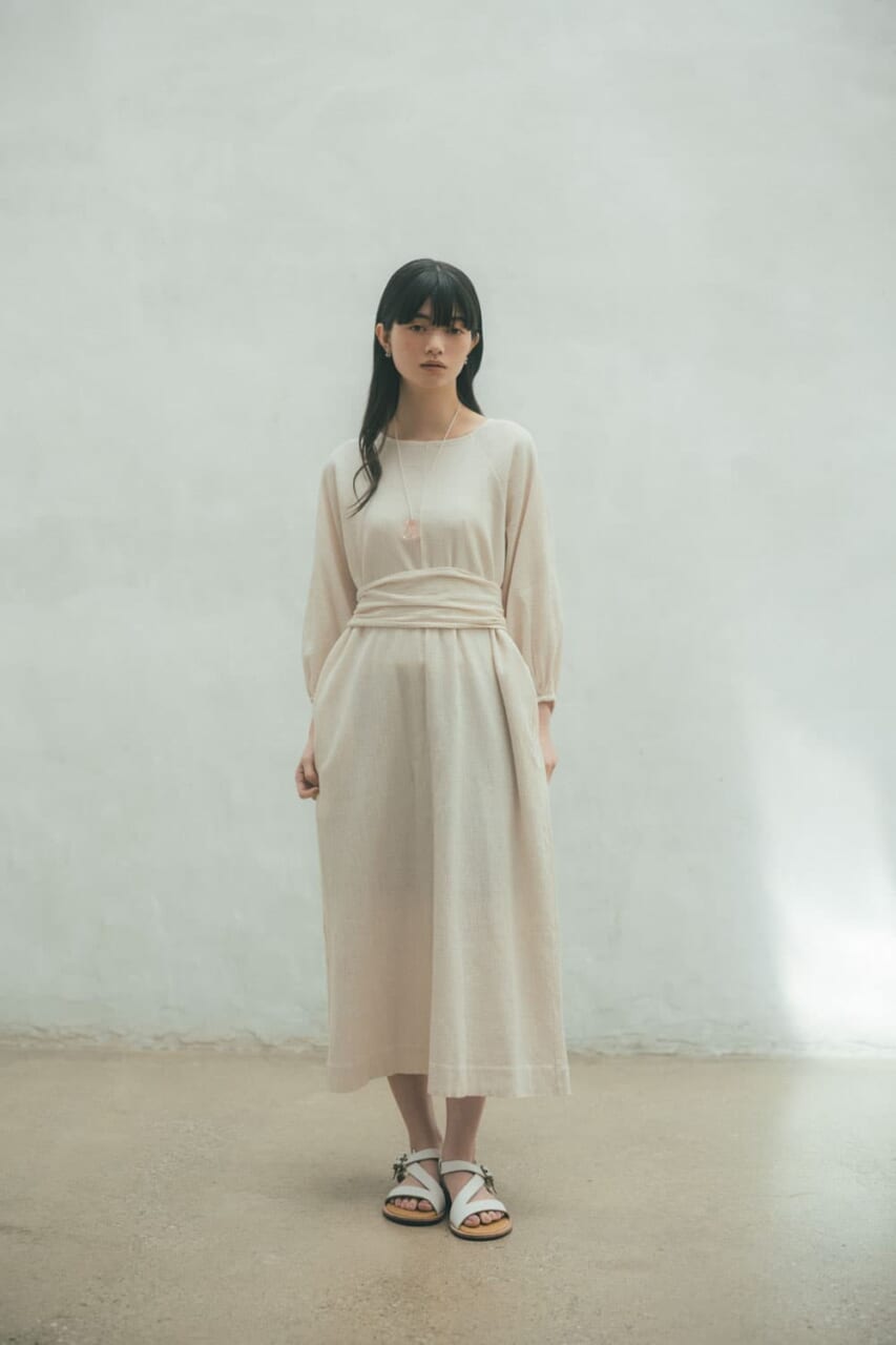 巻き始め背中側にリボンを広げて当て、前でひとねじりして後ろで結ぶ